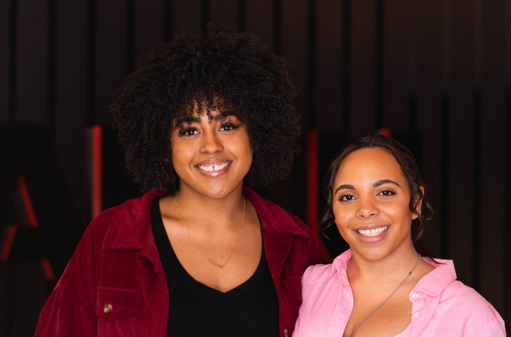 Two women smiling at the camera.