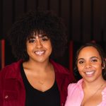 Two women smiling at the camera.
